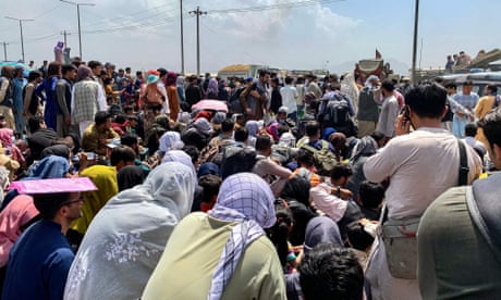Afghan people wait at the airport in Kabul