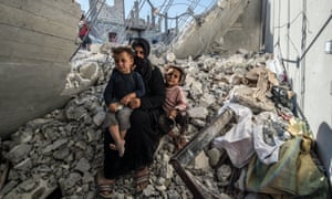 A woman with her children in the rubble of a building in the Jarabulus district