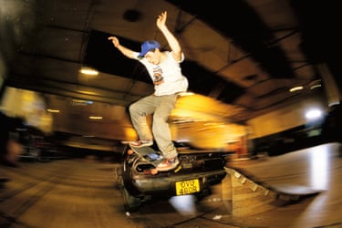 A person skateboarding over a car