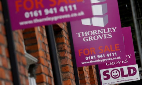 Real estate agents’ boards outside a row of terraced houses in Manchester