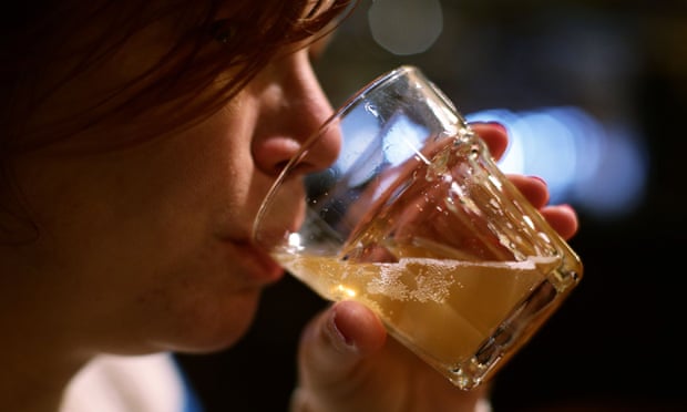 A woman drinks a glass of beer