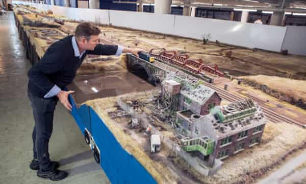 Simon George with his exemplary railway layout, which outgo astir £250,000 to build.