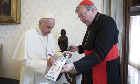 Pope Francis signs a cricket bat given to him by Cardinal George Pell at the Vatican in October 2015.