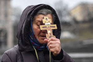 A woman holds a cross as she prays on Independence square in Kyiv