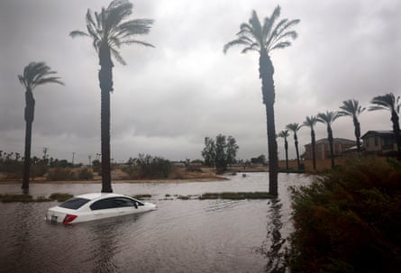 A car is partly submerged in flood waters as Storm Hilary moves through the area on 20 August in Cathedral City, California.
