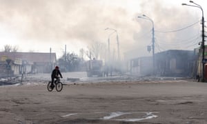 Un homme fait du vélo devant un bâtiment après qu'il a été bombardé à Lysechansk, dans la région de Louhansk, en Ukraine.