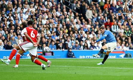 Pascal Gross fires a shot past two Arsenal defenders for Brighton’s first goal.