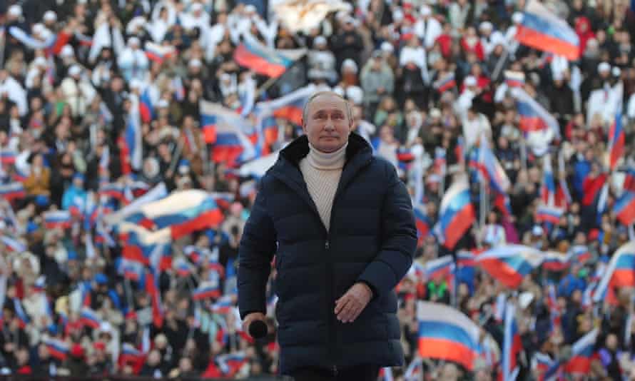 Vladimir Putin aparece frente a los seguidores que ondean la bandera en el Estadio Luzhniki en Moscú