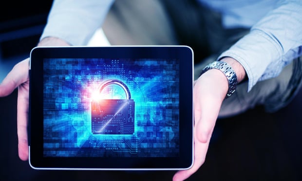 A man holds an electronic tablet with a padlock depicted on the screen