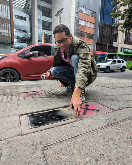 Francisco de Nicolas seeks out loose paving slabs that could soak or trip up unsuspecting pedestrians and casually paints them with a spray can.