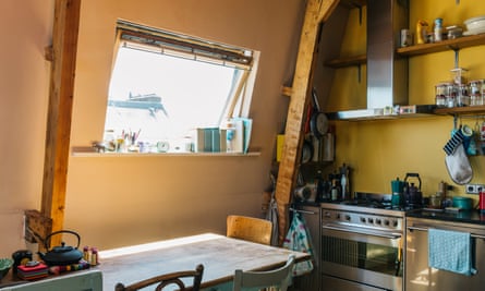Morning sunshine: the open kitchen shelves and window with views across the rooftops.