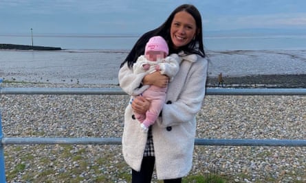 Kiena Dawes with her baby daughter in white coat at seaside
