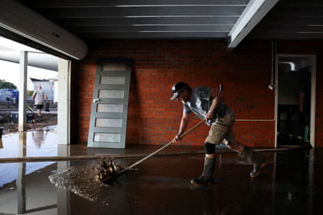 Leigh Halloran clears flood water from his son’s home after flooding in Glenthorne
