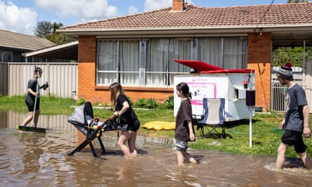 Residents wade through a flooded street in Shepparton.