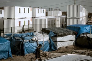 The official shipping container shelters stand in stark contrast to the self-built shelters of the camp.