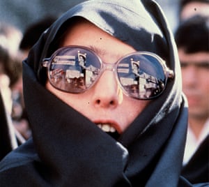 Revolutionary slogans and a portrait of Ayatollah Khomeini are reflected in the glasses of a demonstrator outside of the US Embassy in Tehran, November 1979.