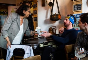 Joëlle, owner of D’Oude Hoeve handing a coffee to Bradley Wiggins