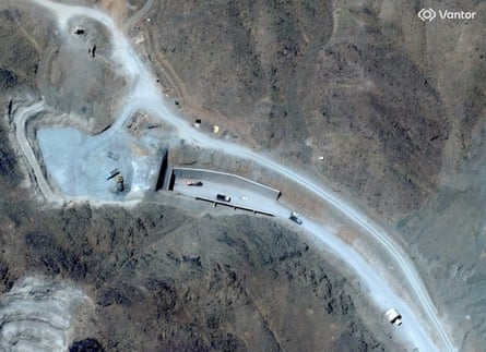 A satellite view shows vehicles at an entrance to the Pickaxe Mountain tunnels.