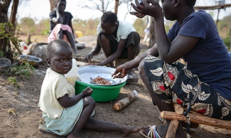 A South Sudanese family eat a meal in the Bidibidi camp in Ugand