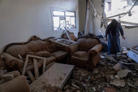 A Palestinian woman inspects a damaged house following Israeli airstrikes on the town of Khan Younis, Gaza, on 3 December 2023.