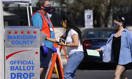 Gönüllüler Phoenix, Arizona'daki Maricopa ilçe kayıt ofisine bakarken seçmenler oy pusulalarını bıraktı.