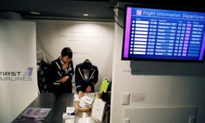 Staff dressed as flight attendants work at the First Airlines, virtual first-class airline check-in desk.