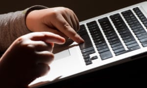 child's hands using a laptop keyboard