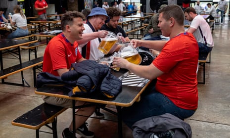 A group of England fans pouring pitchers of beer at Boxpark Wembley in July 2021