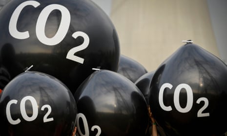Activists hold giant balloons labeled ‘CO2’ in front of the Neurath coal power plant ahead of the Bonn climate summit