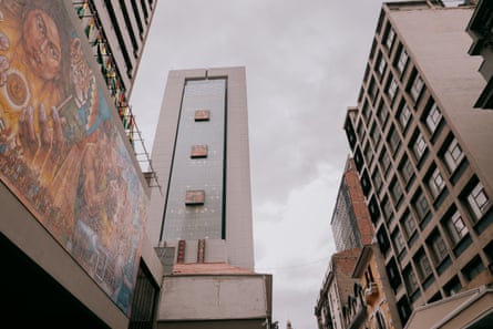 A high-rise building in La Paz Bolivia, photographed from the street level looking up against a grey sky