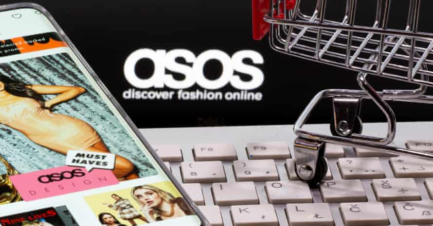 A smartphone with the ASOS app and a keyboard and shopping cart are seen in front of a displayed ASOS logo in this illustration picture taken October 13, 2020. REUTERS/Dado Ruvic/Illustration/File Photo