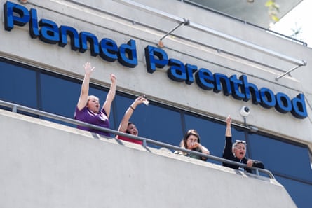 Planned Parenthood workers show support from a balcony during a march in West Hollywood, California.