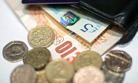 UK coins and banknotes fall out of a wallet