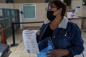 Sylvia Chavez, from Ciudad Juarez, Mexico, shows her proof of vaccination the Paso Del Norte Port of Entry in downtown El Paso, Texas, as she enters the United States for the first time in 20 months to see her father