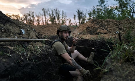 A Ukrainian soldier sits in a trench at the frontline near Bakhmut in the Donetsk region