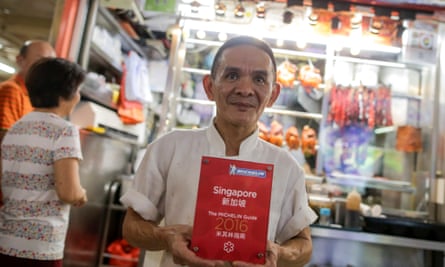 Chan Hong Meng, the owner of Hong Kong Soya Sauce Chicken Rice and Noodle, poses with his Michelin Award in front of his store in Singapore.