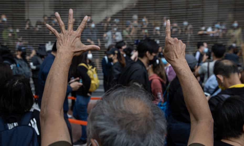 Pro-democracy activists gesture ‘five demands, not one less’ in support of arrested fellow activists outside the West Kowloon Court in Hong Kong