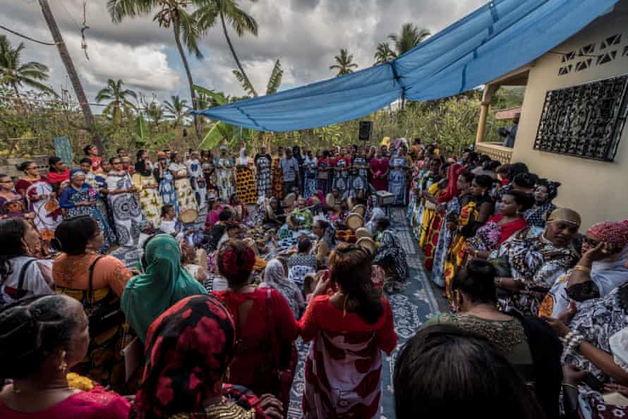Female wedding guests dance and play drums outside the house of the bride on the third day of the wedding