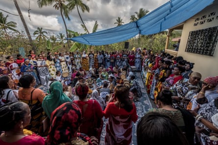 Female wedding guests dance and play drums outside the house of the bride on the third day of the wedding