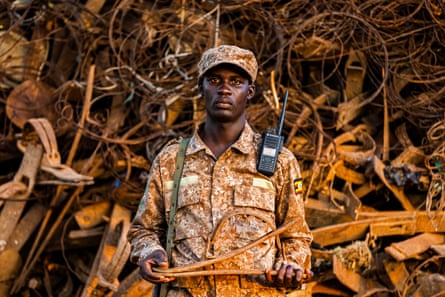 A ranger stands in front of the snare mountain holding a trap