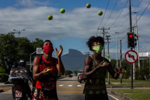 Boys wearing masks juggle tennis balls at the traffic light in Barra da Tijuca. For many years, people who walk the streets of Rio have been used to seeing children and young people who have found a way to earn money by juggling. These boys and girls get the sympathy of most people who stop at traffic lights because, in a way, they are street performers and not simply beggars.