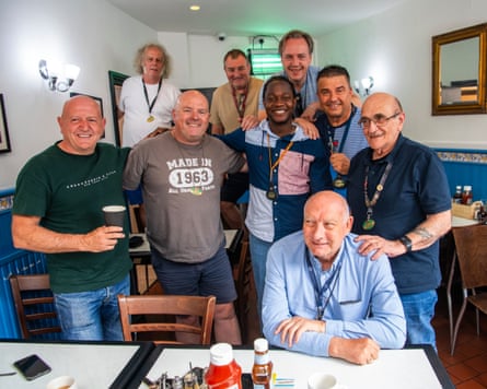 Mujagata poses for a photo with long-serving taxi drivers in a cafe