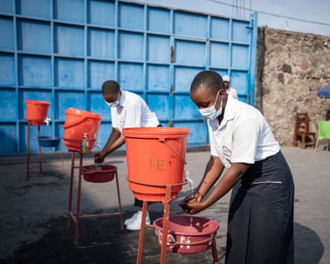 A student washing their hands under water running into a red bowl