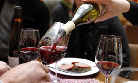 A waiter pours glasses of Beaujolais Nouveau wine at an event in Paris