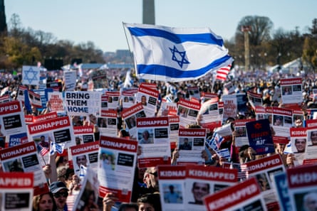 People hold Israeli flags and posters of hostages