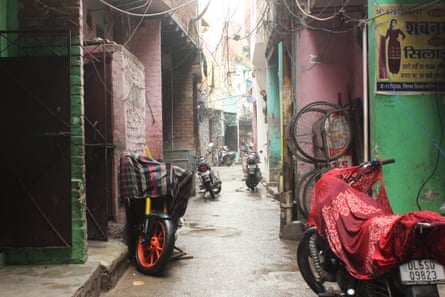 A very narrow street with motorbikes parked in it