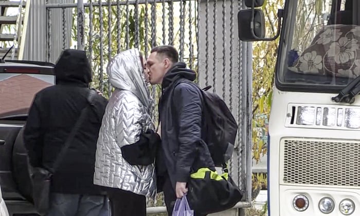 A Russian draftee kisses his partner before boarding a bus to be sent to the military units of the Eastern Military District, in Yakutsk, Russia.