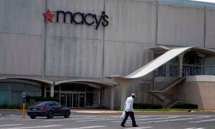 A man walks through an empty parking of a Macy’s store in Camp Springs, Maryland. The true scale of Covid-19’s impact on the US economy is yet to be determined.