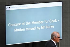 Scott Morrison walks in parliament past a screen that has large text on it saying 'Censure of the member for Cook - motion moved by Mr Burke'