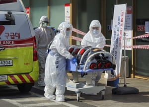 Medical staff move a patient suspected of contracting the coronavirus in Daegu.